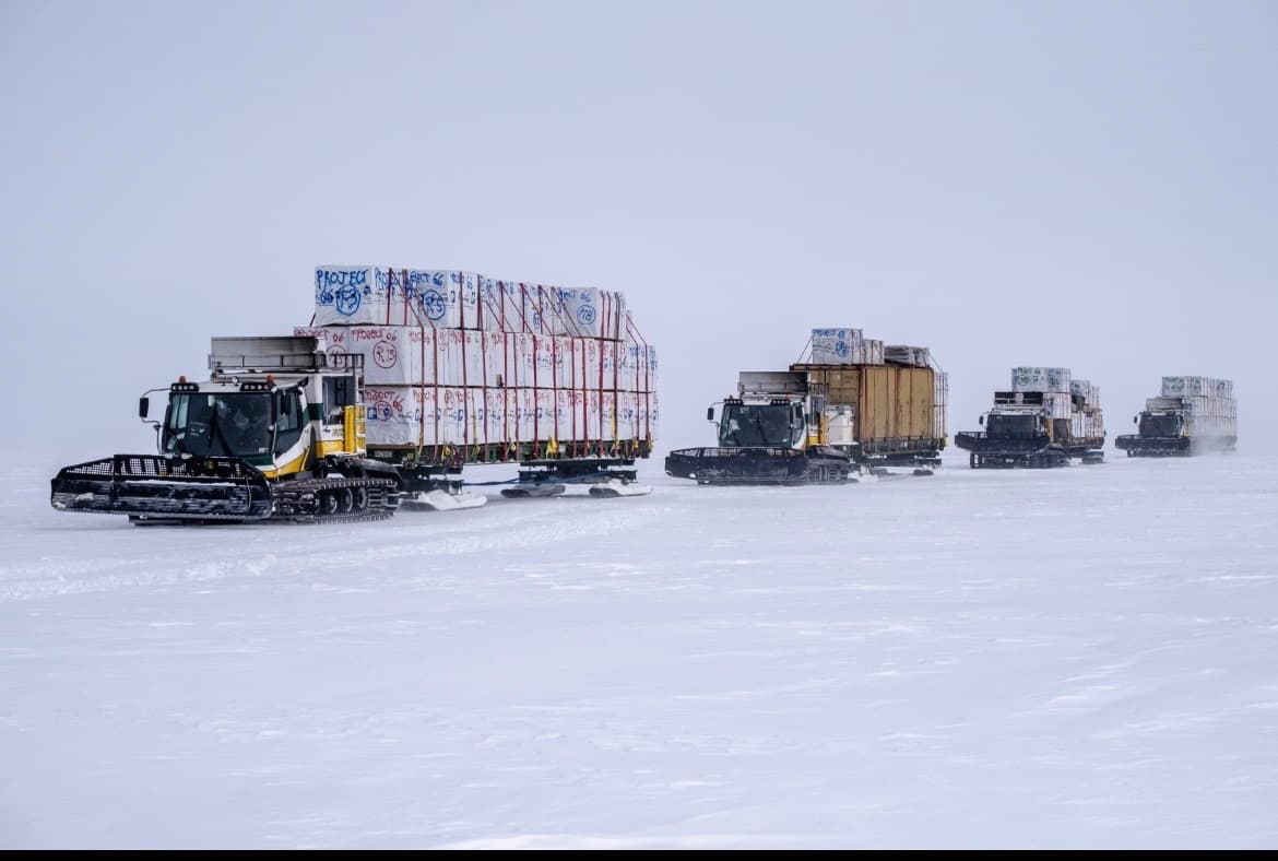 A convoy of tracked prime movers pulling Mammoth Pull Sleds sleds across open arctic tundra.