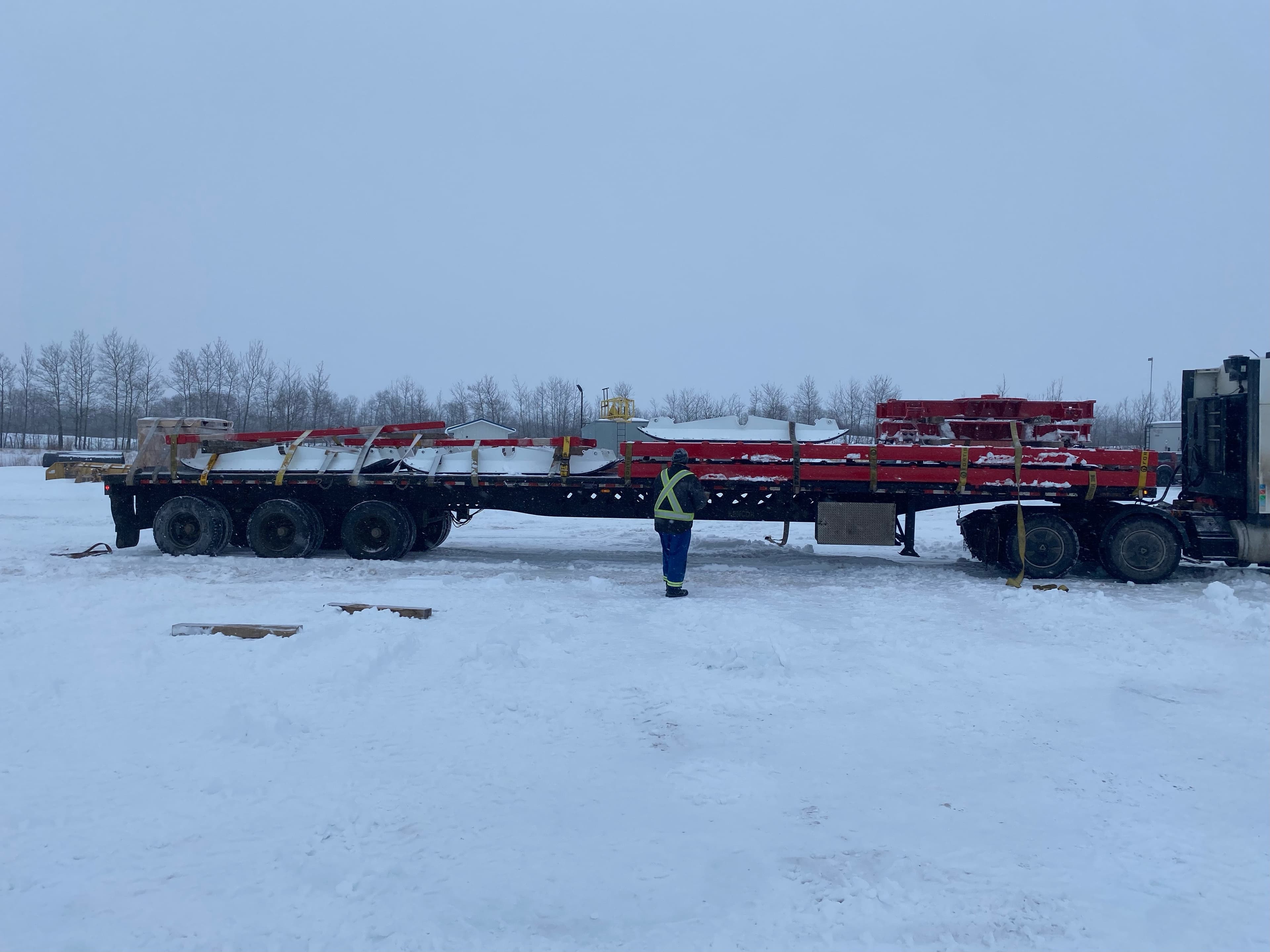 Mammoth sled assemblies staged and loaded in a snowy yard.